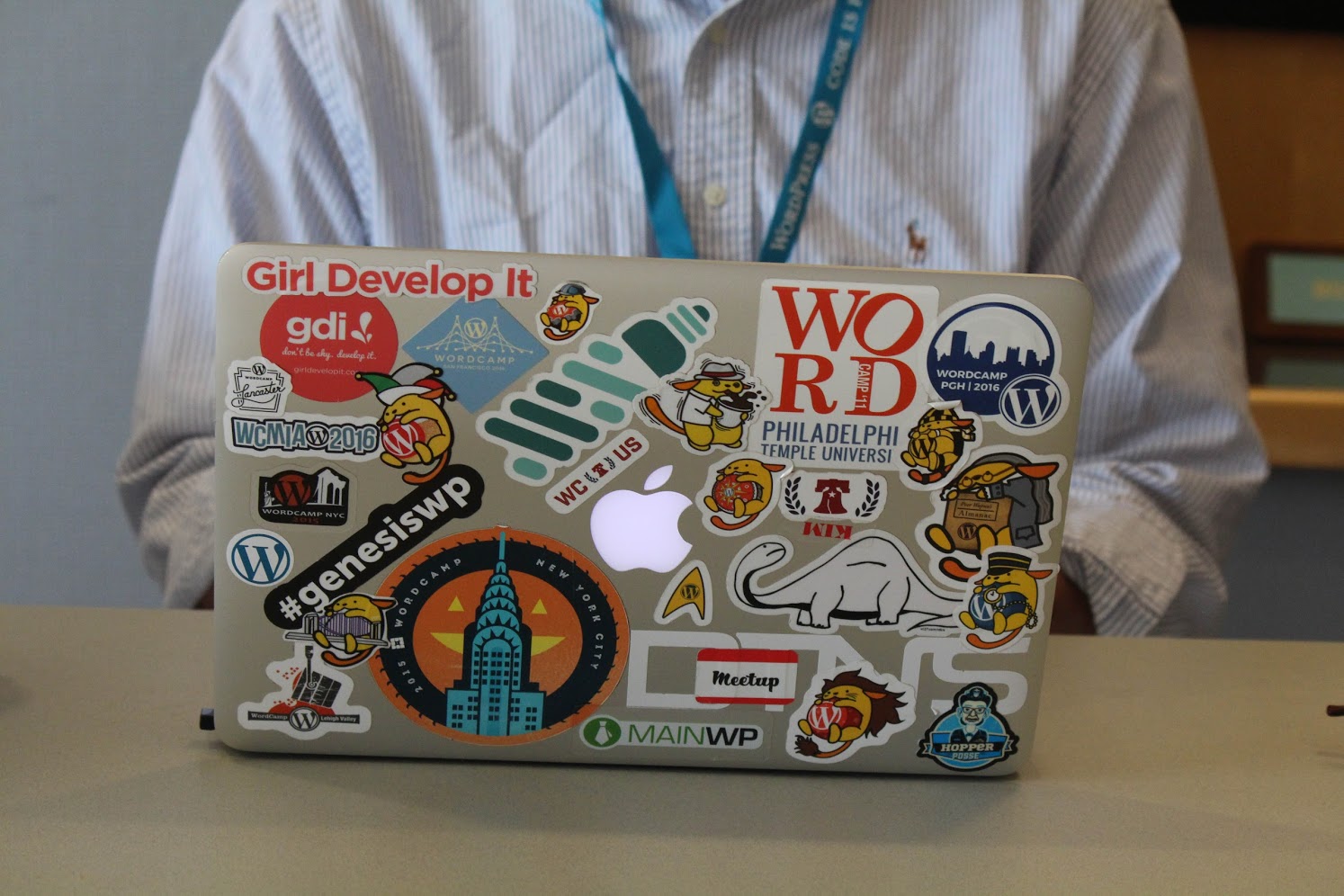 MacBook covered with WordPress, WordCamp, and sponsor stickers
